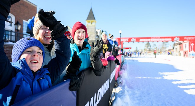 family cheering for birkie ski racers near the finish line