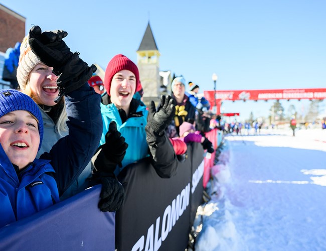 family cheering for birkie ski racers near the finish line