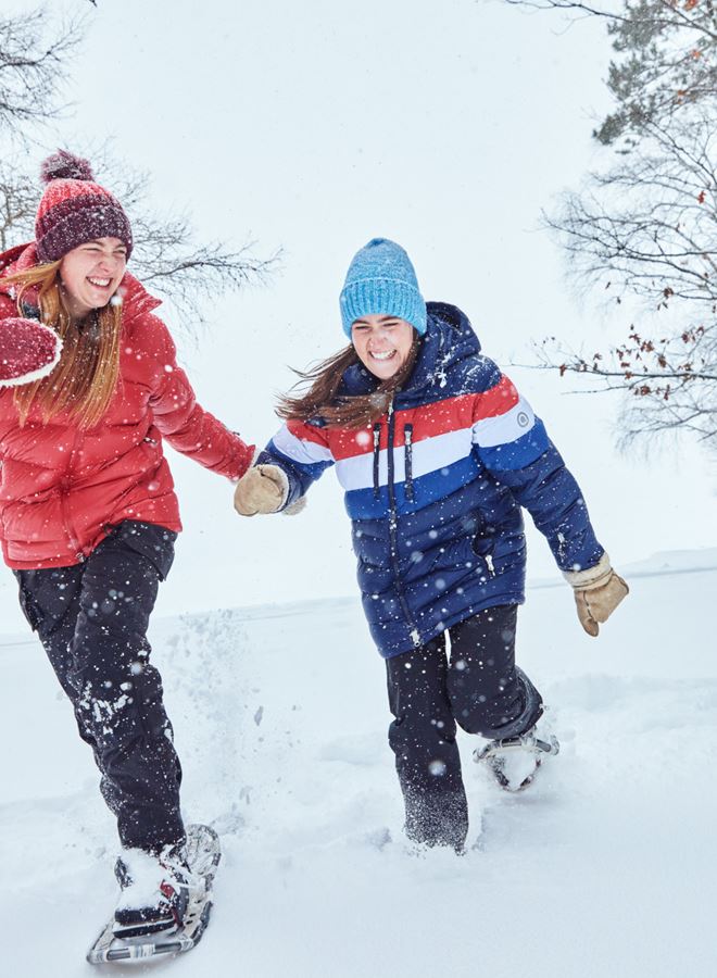 Friends Play In The Snow On Snowshoes Near The Coon's Franklin Lodge In Woodruff